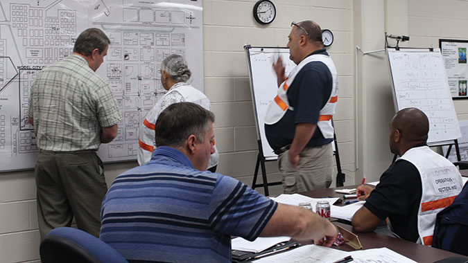 Responders in the Incident Command: Capabilities, Planning and Response Actions for All Hazards (IC) course review an area map as they plan the response to an incident.