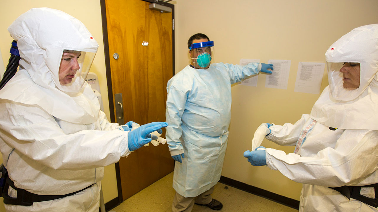 Students practice putting on and removing personal protective equipment in the Barrier Precautions and Controls for Highly Infectious Disease (HID) course.