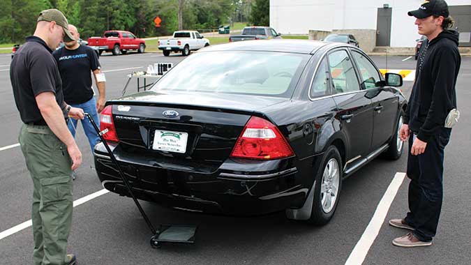Students in the Vehicle-Borne IED Detection course use mirrors to exam the undercarriage of a car during a practical exercise. The course is an eight-hour, one-day course that is offered as part of several of the CDP’s law enforcement training programs.