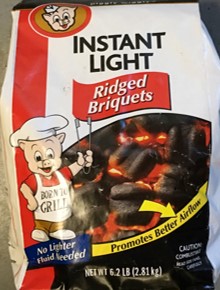Image of a red and white bag of charcoal briquets, with the words Instant Light at the top in black and underneath the words Ridged Briquets in white letters in a red banner.