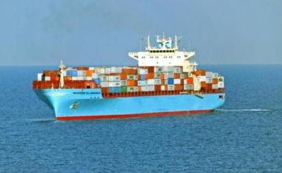 Image of a large sea vessel transporting numerous shipping containers on its deck.